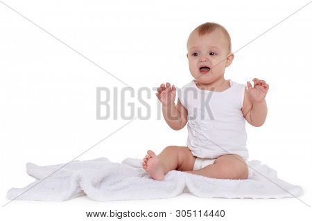 Little crying baby in diaper is sitting on a plaid on white background. Eight months