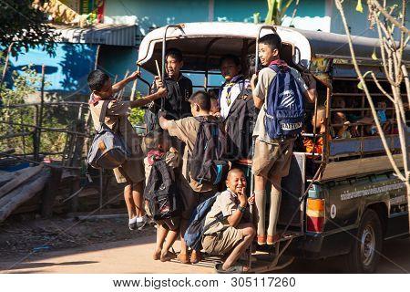 SAKON NAKHON, THAILAND JANUARY 23, 2019 - Group of young boys leaving school on a school bus in the village of Akat Amnuai, Sakon Nakhon province, Thailand.
