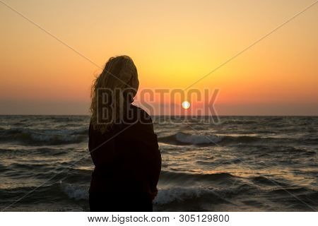 Silhouette Of A Girl On The Beach At Sunrise