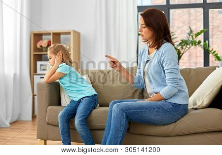misbehavior, conflict and family concept - angry mother scolding her daughter at home