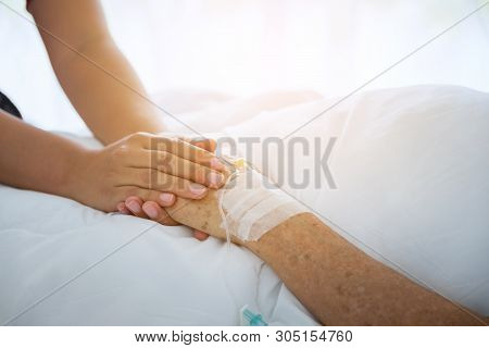 Medical Doctor Holing Senior Patient's Hands And Comforting Her, Hand Of Man Touching Senior Woman I
