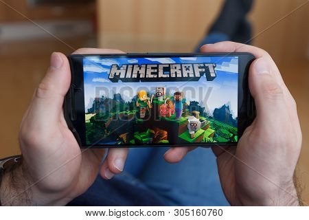 Los Angeles, California - June 3, 2019: Lying Man Holding A Smartphone And Playing Minecraft Game On