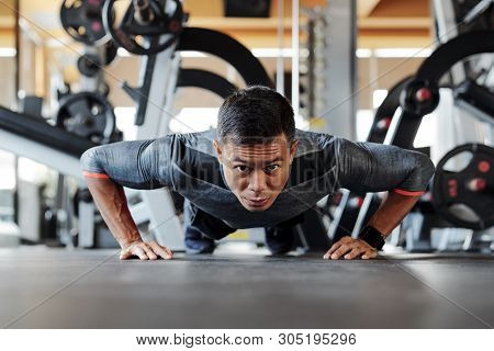 Young Asian Sportsman Wearing Rashguard When Doing Push Ups On Gym Floor