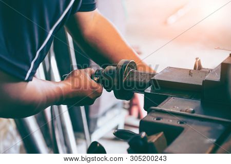 Professional Machinist : Man Operating Lathe Grinding Machine - Metalworking Industry Concept. Mecha