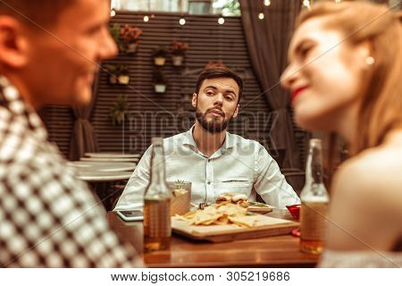 Jealous Gentleman Looking At His Flirting Friends At The Bar