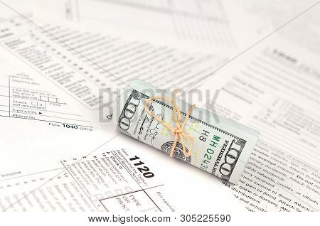 1120 U.s. Corporation Income Tax Return Form With Roll Of American Dollar Banknotes