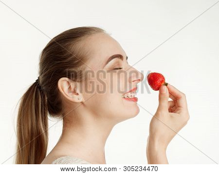 Beautiful Girl Makes Makeup Strawberry Berries On A White Background