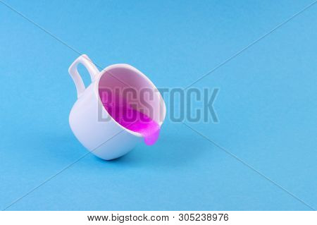 Bright Pink Glitter Slime Comes Out Of Mug. White Cup On Pink Background. Art Neon Surrealism And Mi