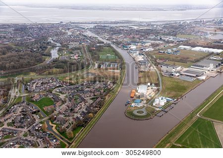 Aerial View Dutch Residential Area Delfzijl With Channel Eemskanaal And Industrial Park Near Harbor