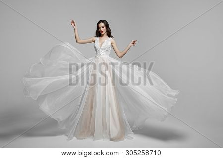 Beauty Portrait Of A Young Woman In Wedding Fashion Long Dress In Waving Flying Fabric, Cloth Flutte