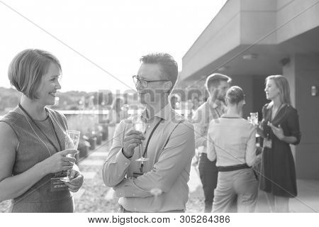 Black and White photo of Mature business colleagues talking during success party on rooftop