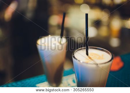 Two Delicious Thick Icecream Milkshakes Garnished With Chocolate And Mint And Served In Tall Chilled