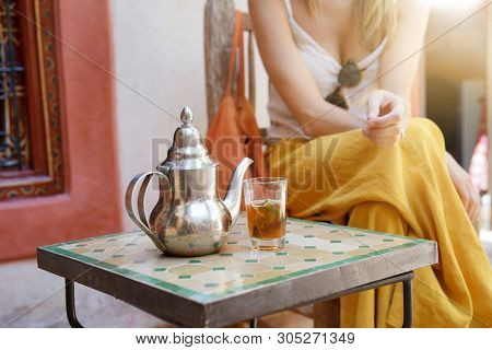 Elegant woman dirnking mint tea in Moroccan riad