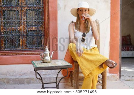 Elegant woman dirnking mint tea in Moroccan riad