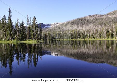 Hyalite Lake, Bozeman, Montana, The Water Is Still As Glass, The Mountains And Trees Reflecting Onto