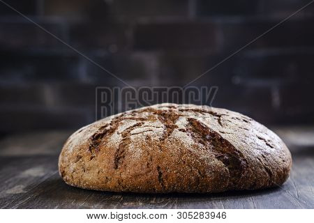 Freshly Baked Round Sourdough Bread And Rye Ears On Wooden Table. Rustic Style. Selective Focus. Cop