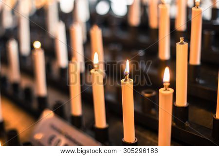 Color Image Of Rows Of Candles Burning In A Church.