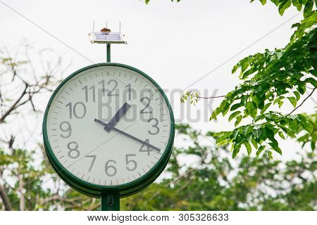 The Green Clock In The Park Is Powered By The Sun.