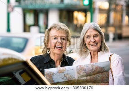 Two Women In A City Center Sharing A Road Map