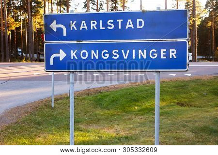 Signpost Located At The Border With Direction To The Swedish City Karlstad And The Norwegian Town Ko