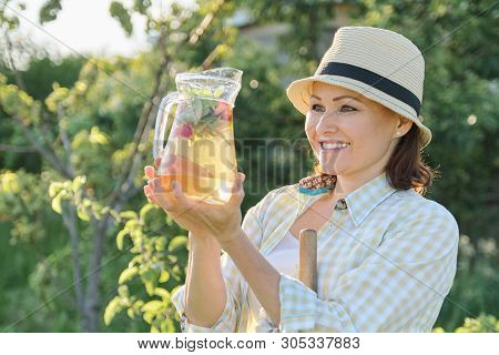 Summer Outdoor Portrait Of Woman With Natural Drink Made From Strawberry Mint Herbs, Woman Gardening