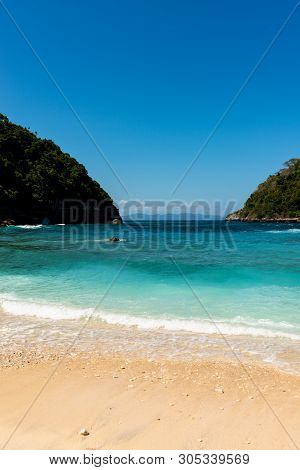 View Of Tropical Beach, Sea Rocks And Turquoise Ocean, Blue Sky. Atuh Beach, Nusa Penida, Indonesia