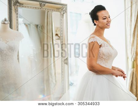 Beautifu bride choosing wedding dress in a wedding salon