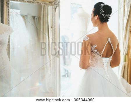 Beautifu bride choosing wedding dress in a wedding salon