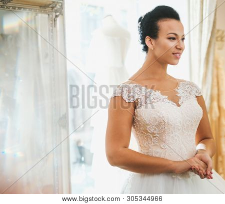Beautifu bride choosing wedding dress in a wedding salon