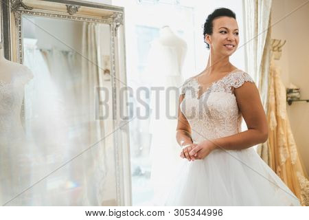 Beautifu bride choosing wedding dress in a wedding salon
