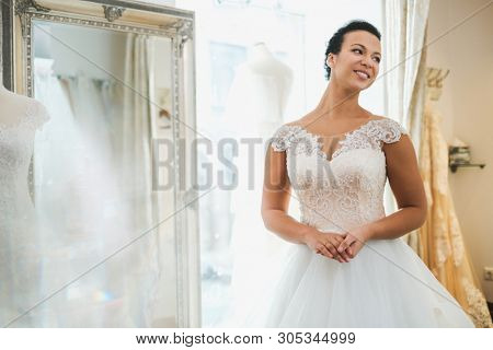 Beautifu bride choosing wedding dress in a wedding salon