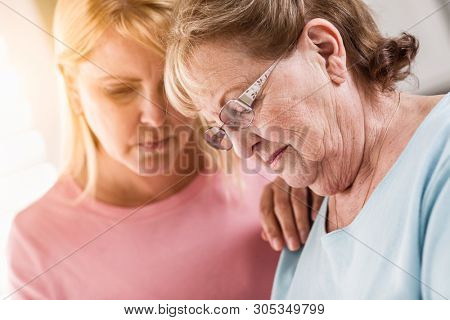 Young Adult Woman Consoles Sad Senior Adult Female.