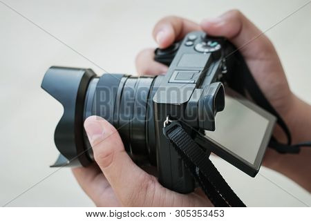 Production  Movie Video Concept : Professional Videographer Or Photographer Holding Mirrorless Camer