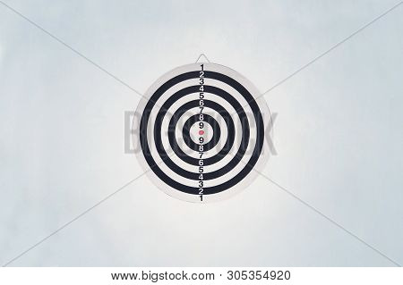 Dartboard On Blue Wall. Darts A Series Of Related Games In Which Players Throw Darts At A Round Targ