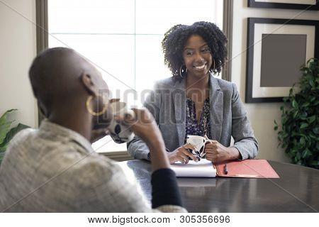 Black African American Female Businesswomen Talking In An Office.  The Two Women Looks Like A Start 