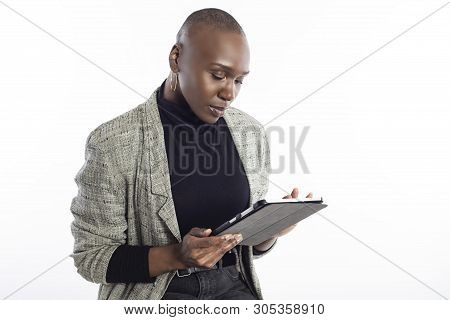 Black African American Female Teacher Preparing Her Course Or Lessons Online With A Tablet Computer.