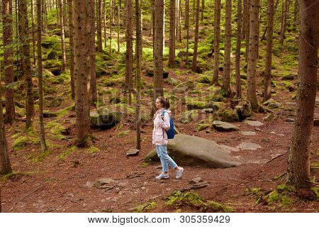 Profile Of Young European Female Wandering In Forest Around Trees, Green And Stones, Wearing Light P