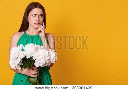 Half Length Portrait Of Attractive Brunette Woman In Green Sundress Holding Bouquet Of White Peonies