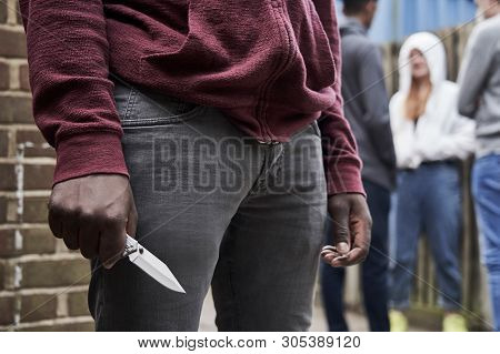 Close Up Of  Teenage Boy In Urban Gang Holding Knife