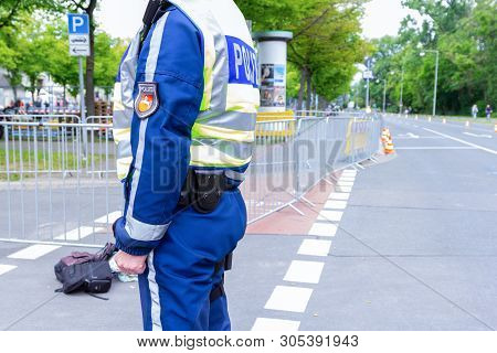 Hanover / Germany - May 25, 2019: German Police Officer Stands On A Street To Secure An Event. The G