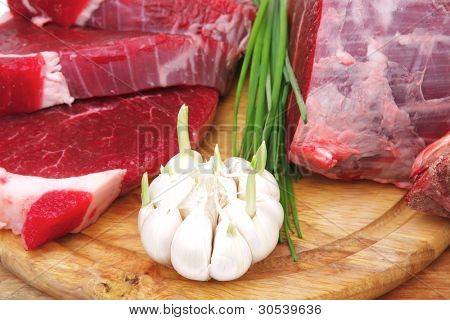slagteri: frisk råt oksekød lamb store rib og filet klar til madlavning med grønne ting på træplade 