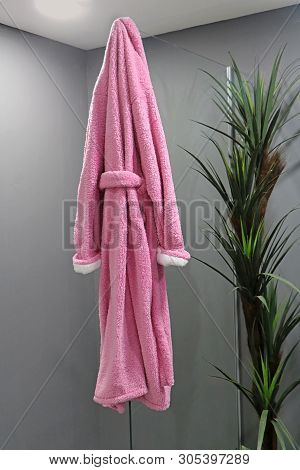 Soft Pink Bath Robe Hanging On The Glass Inside Spa Interior