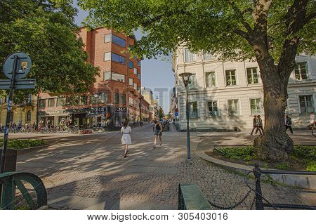 View Of Street Of Uppsala. People Cycling And Walking Along.  Beautiful City Landscape On Blue Sky B