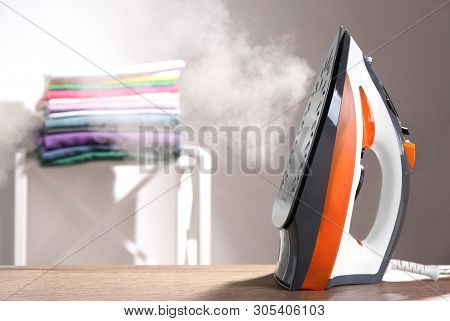 Modern Iron With Steam On Table Indoors. Space For Text