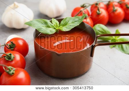 Pan Of Tasty Tomato Sauce With Basil Served On Grey Table