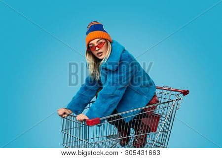Insane Female Dapper In Bright Outfit Looking At Camera While Riding Trolley During Shopping Against