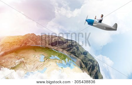 Happy Pilot Driving Small Propeller Plane On Background Of Blue Sky With Clouds. Traveling Around Th