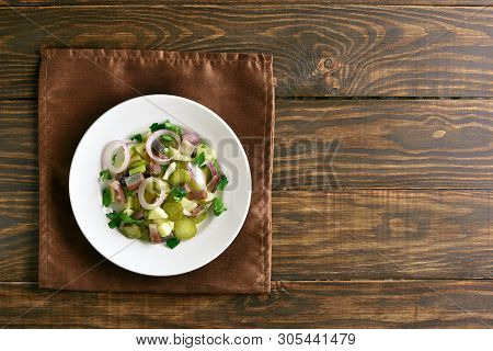 Fish Salad With Marinated Herring, Potato, Onion, Picles And Apple On Wooden Background With Copy Sp