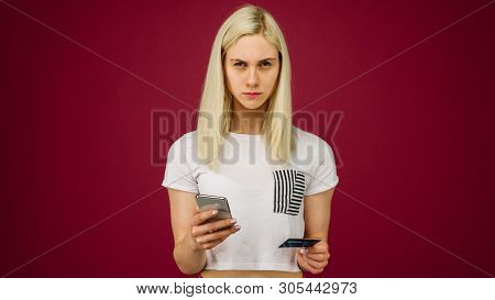 A Young Woman Holds A Smartphone And A Credit Card In Her Hands. Problems With A Bank Card, Because 