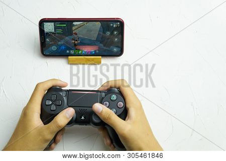 Bishkek, Kyrgyzstan - June 06, 2019: Man Playing Fortnite On Ios 13 With Sony Dualshock